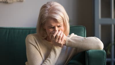 Middle aged woman crying on a couch